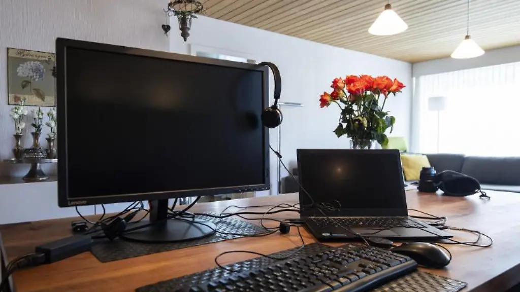 Ein-Laptop-Bildschirm-und-Kopfhoerer-liegen-fuer-die-Arbeit-im-Home-Office-bereit