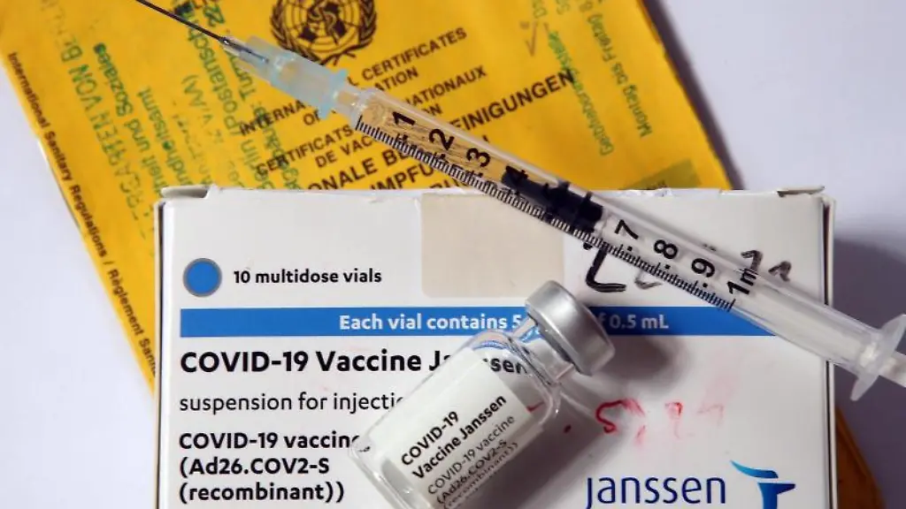 Eine-Spritze-und-eine-Ampulle-des-Impfstoffs-von-Johnson-Johnson-liegen-auf-der-Verpackung
