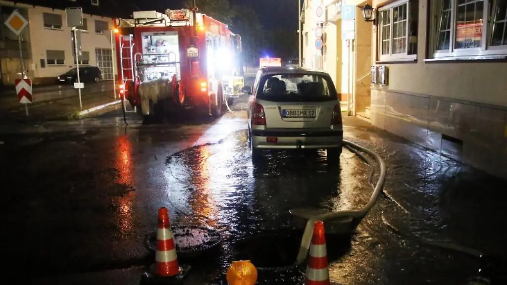 Ein-Feuerwehrauto-steht-in-einer-vom-Unwetter-verschmutzten-Strasse