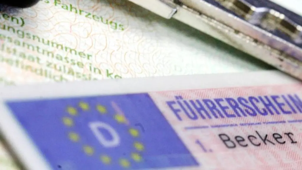Ein-Fuehrerschein-und-ein-Autoschluessel-liegen-auf-einem-Fahrzeugschein