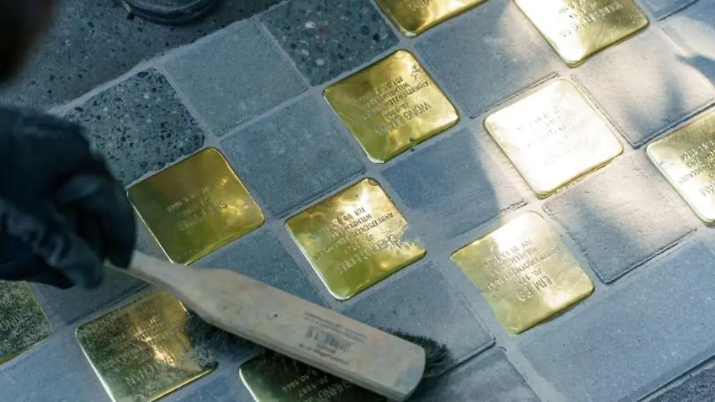 Gunter-Demnig-Kuenster-fegt-die-von-ihm-verlegten-Stolpersteine-in-der-Talstrasse-ab