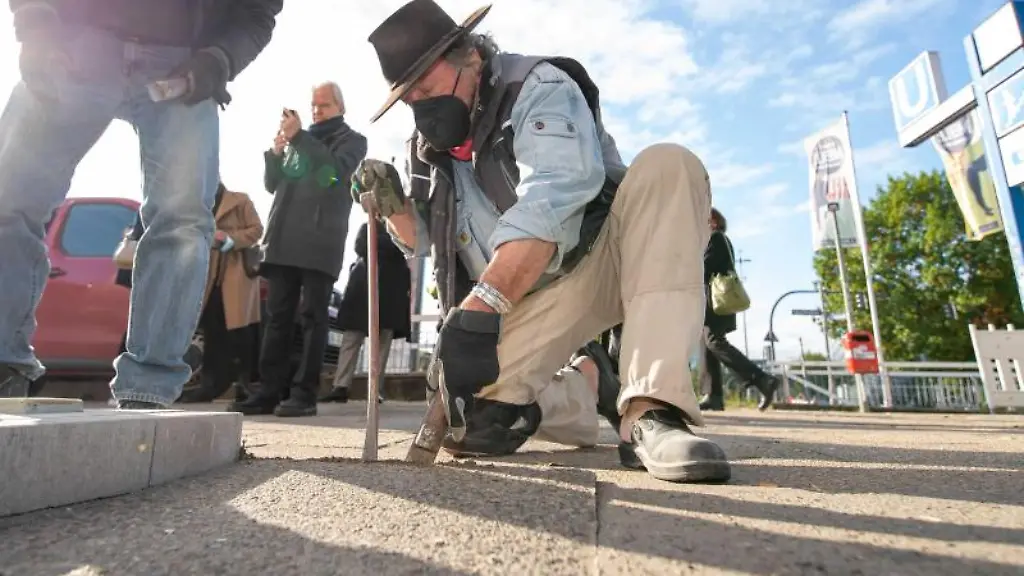 Kuenstler-Gunter-Demnig-M-kniend-verlegt-die-Stolpersteine
