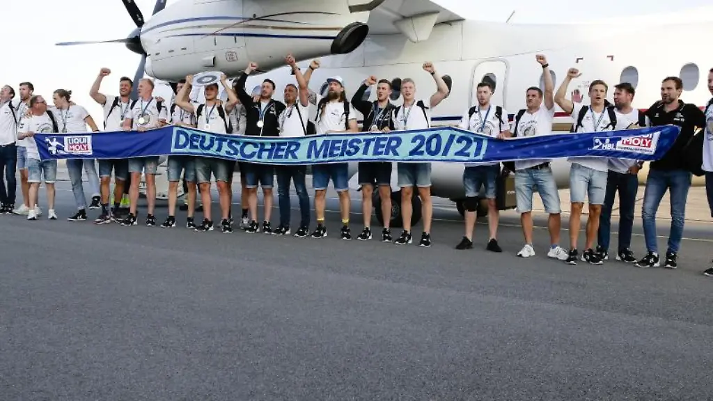 Die-Spieler-des-Deutschen-Handballmeisters-THW-Kiel-stehen-auf-dem-Rollfeld-des-Flughafens-in-Kiel-zusammen