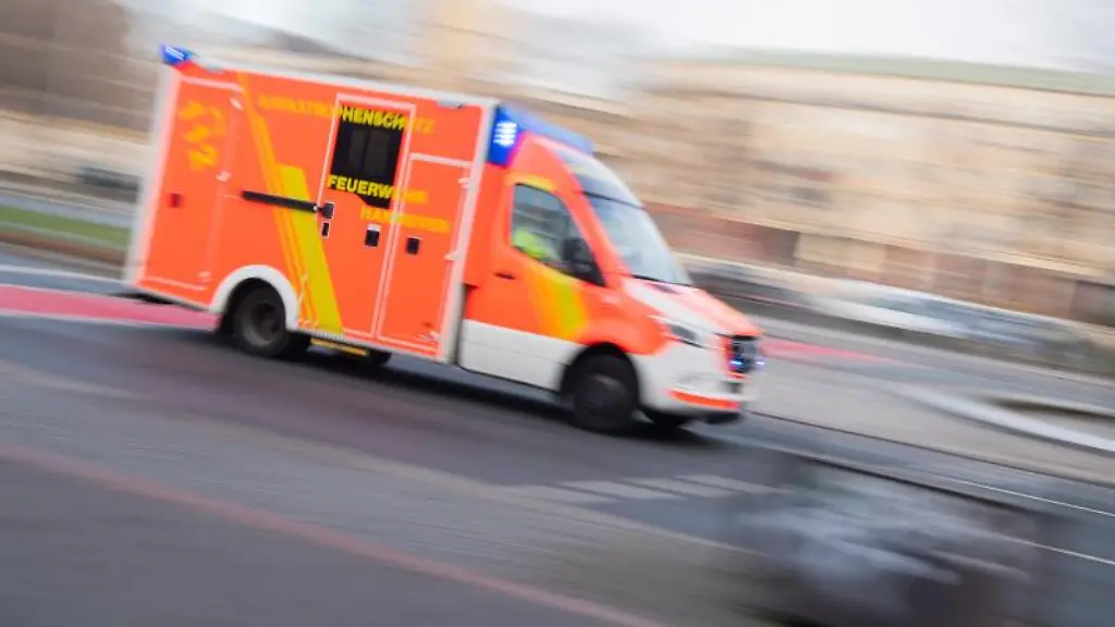 Ein-Rettungswagen-faehrt-mit-Blaulicht-durch-die-Innenstadt