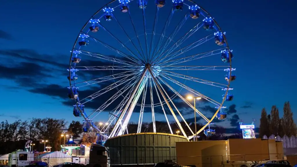 Ein-Riesenrad-leuchtet-am-Abend-auf-dem-Schuetzenplatz-in-Hannover