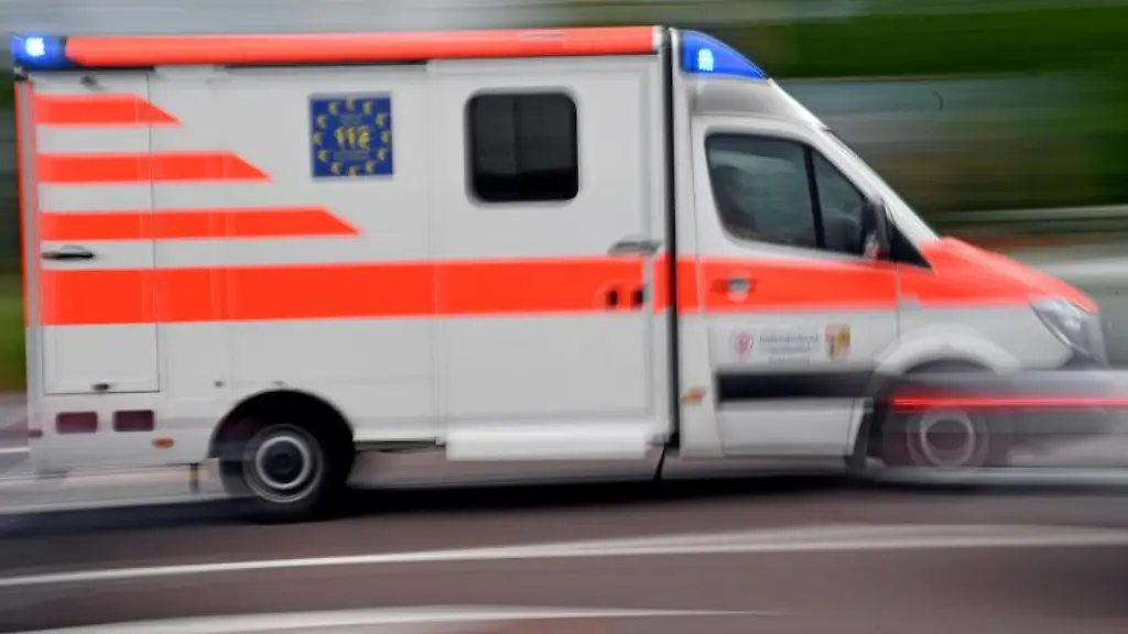 Ein-Krankenwagen-faehrt-mit-Blaulicht-auf-einer-Strasse