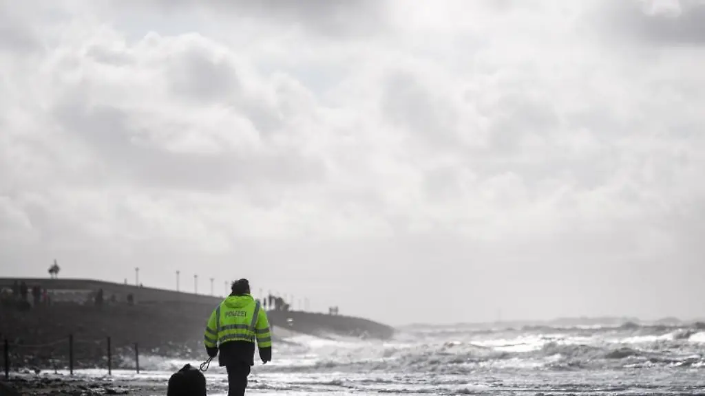 Inselpolizistin-Heike-Cleve-geht-mit-ihrem-Hund-Split-am-Strand-von-Baltrum-entlang