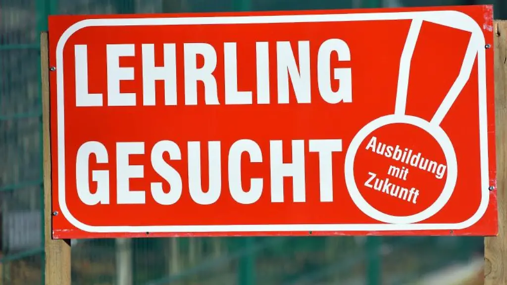 Ein-Schild-mit-Lehrling-gesucht-Ausbildung-mit-Zukunft-ist-vor-einem-Zaun-aufgestellt