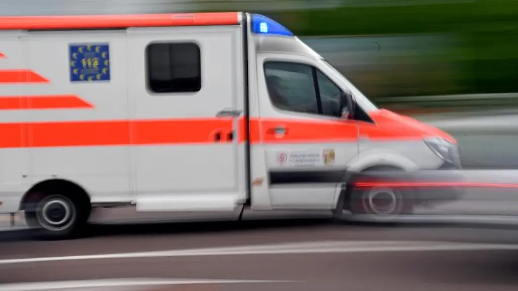 Ein-Krankenwagen-faehrt-mit-Blaulicht-auf-einer-Strasse