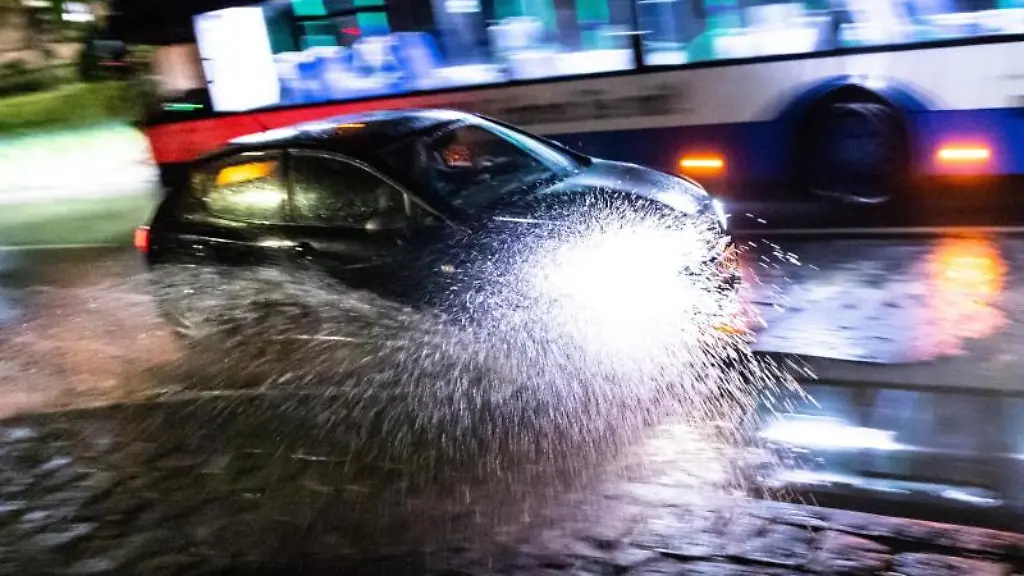 Ein-Auto-faehrt-durch-eine-Unterfuehrung-die-nach-einem-Gewitter-mit-Starkregenschauer-ueberschwemmt-ist
