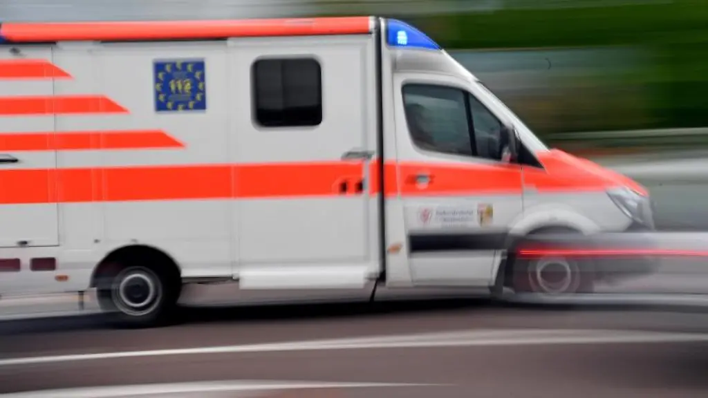 Ein-Krankenwagen-faehrt-mit-Blaulicht-auf-einer-Strasse