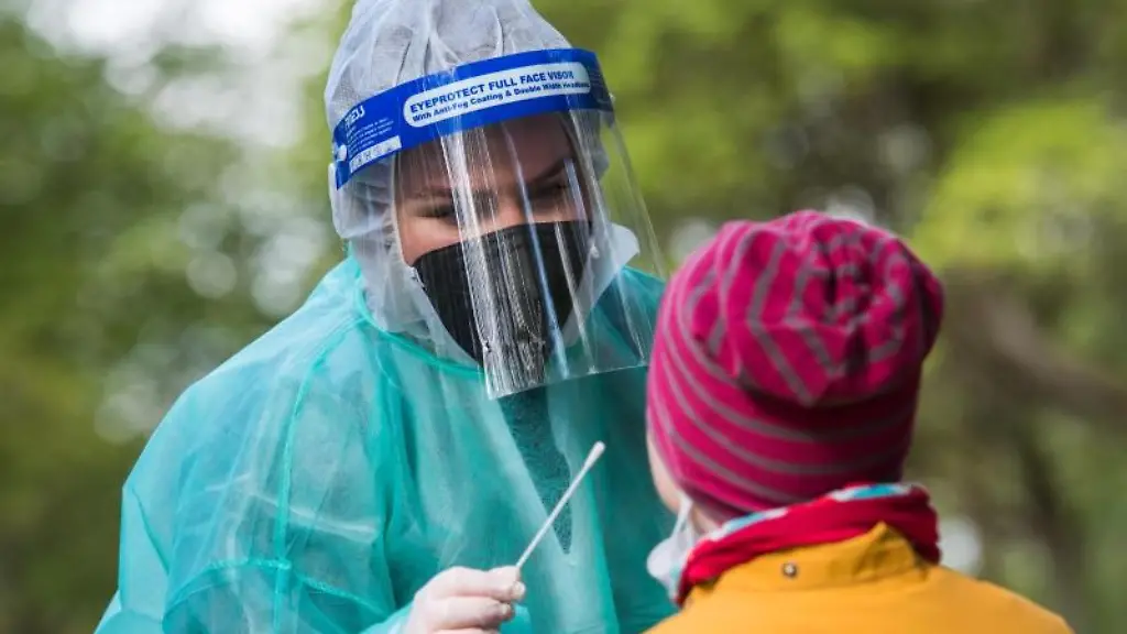 Eine-Mitarbeiterin-in-einem-Corona-Testzentrum-macht-bei-einem-Maedchen-einen-Corona-Test