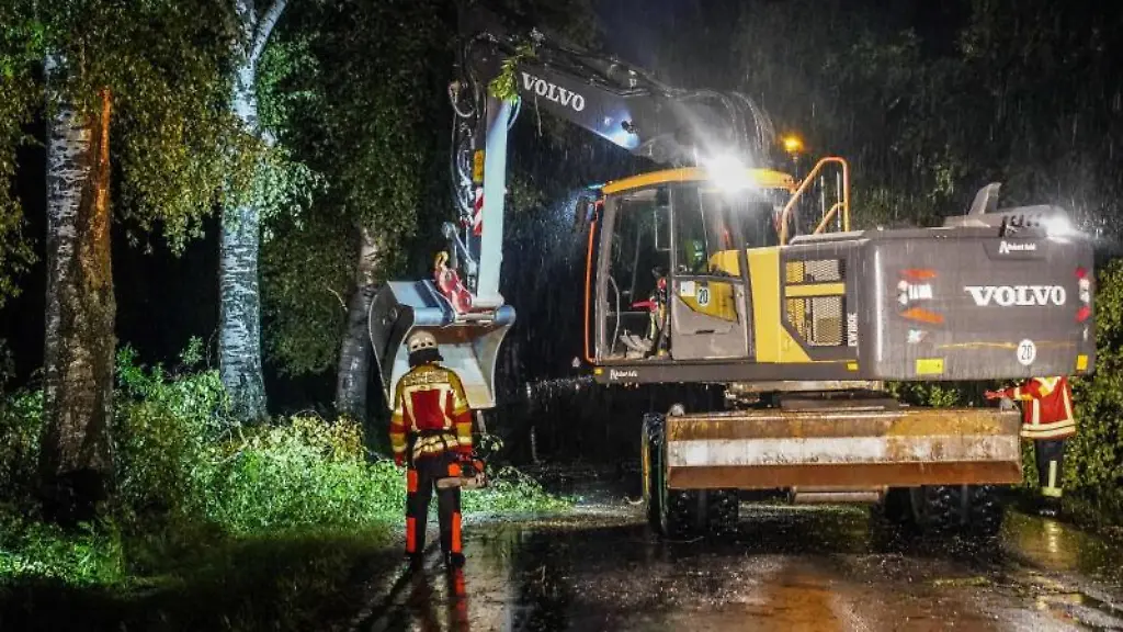 Mit-schwerem-Geraet-raeumen-Helfer-eine-Strasse-im-Alb-Donau-Kreis-frei