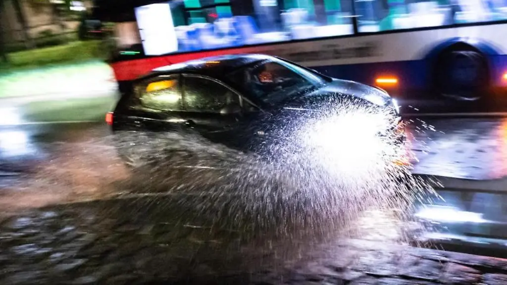 Ein-Auto-faehrt-durch-eine-Unterfuehrung-die-nach-einem-Hitzegewitter-ueberschwemmt-ist