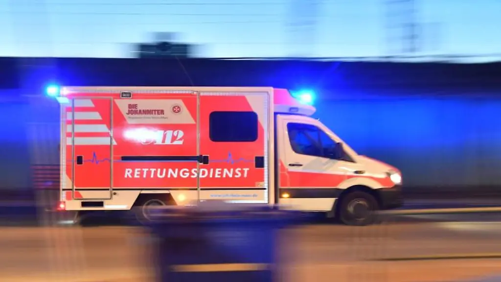 Ein-Rettungswagen-mit-eingeschaltetem-Blaulicht-faehrt-auf-einer-Strasse
