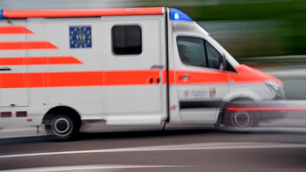 Ein-Krankenwagen-faehrt-mit-Blaulicht-auf-einer-Strasse