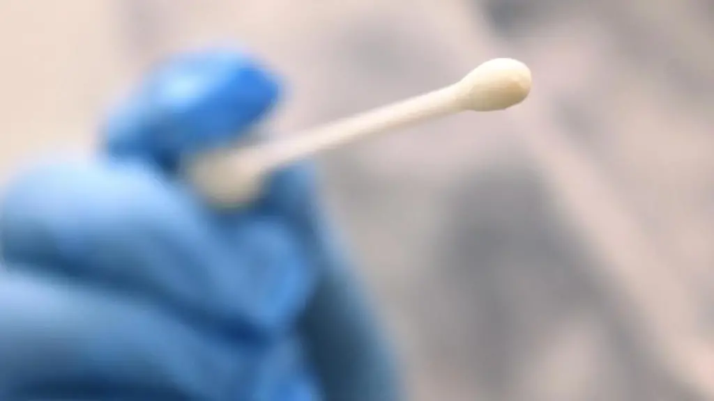 Ein-Arzt-haelt-einen-Tupfer-mit-dem-ein-Abstrich-fuer-einen-Coronatest-gemacht-wird