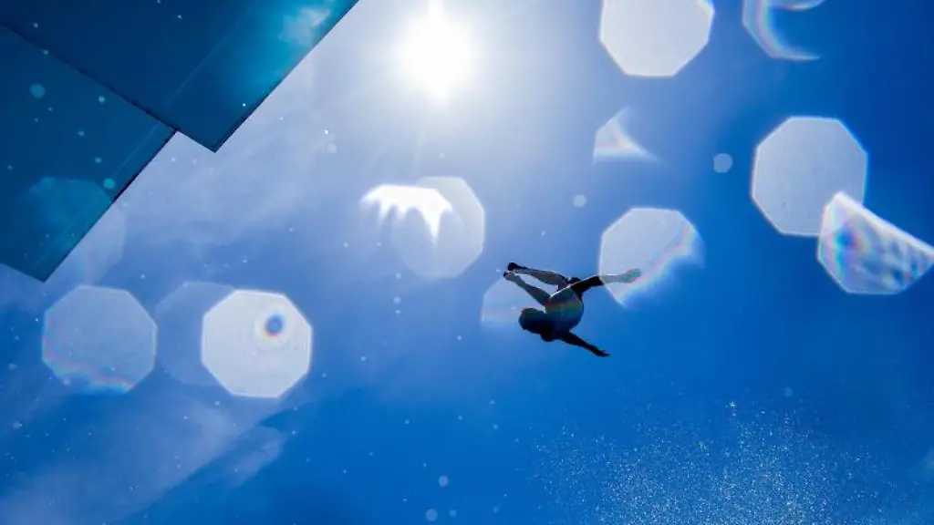 Ein-Freizeitsportler-springt-bei-strahlendem-Sonnenschein-vor-blauem-Himmel-vom-7-1-2-Meter-Sprungturm