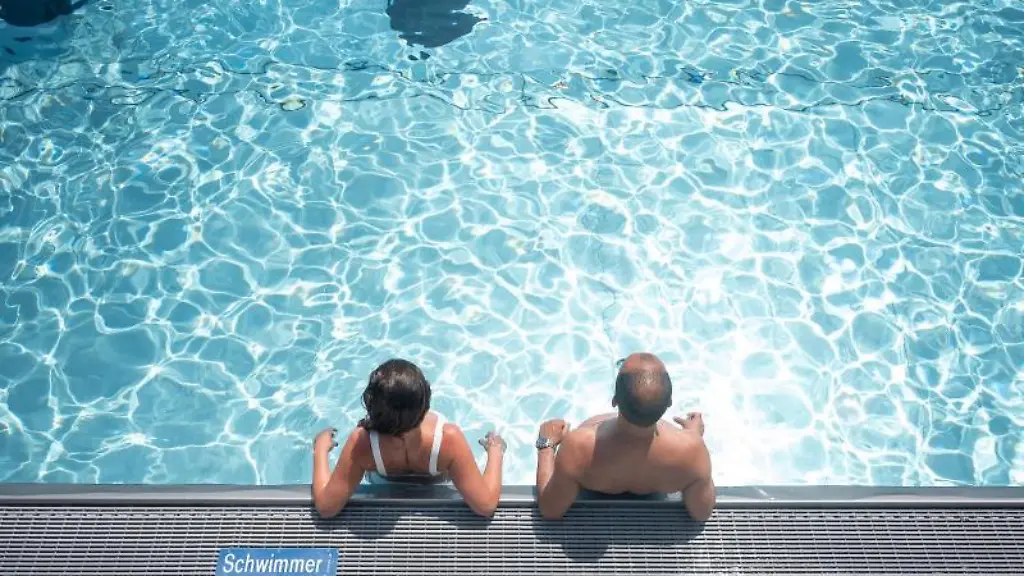 Zwei-Badegaeste-stehen-in-einem-Schwimmbecken