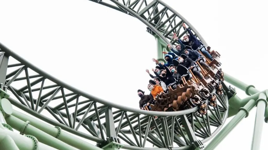 Besucher-sitzen-mit-Mund-Nasen-Bedeckungen-im-Hansapark-in-einem-Fahrgeschaeft