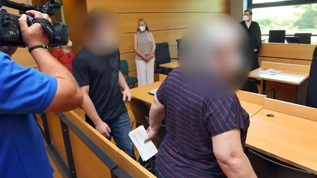 Ein-Frau-r-und-ihr-Sohn-betreten-den-Gerichtssaal-im-Amtsgericht