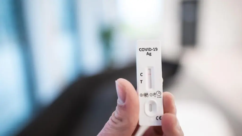 Ein-Mann-haelt-einen-Corona-Schnelltest-in-der-Hand