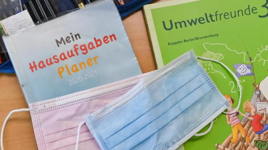 Masken-liegen-auf-Arbeitsmaterialien-eines-Schuelers