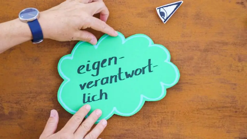 Eine-Mediatorin-platziert-eine-Sprachblase-mit-der-Aufschrift-eigenverantwortlich-auf-einer-Tafel