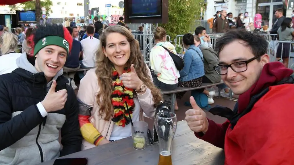 Jakub-l-r-Lisa-und-Alex-sitzen-bei-einem-Public-Viewing