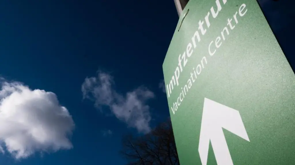 Ein-Schild-mit-einem-Pfeil-weist-den-Weg-zu-einem-Impfzentrum