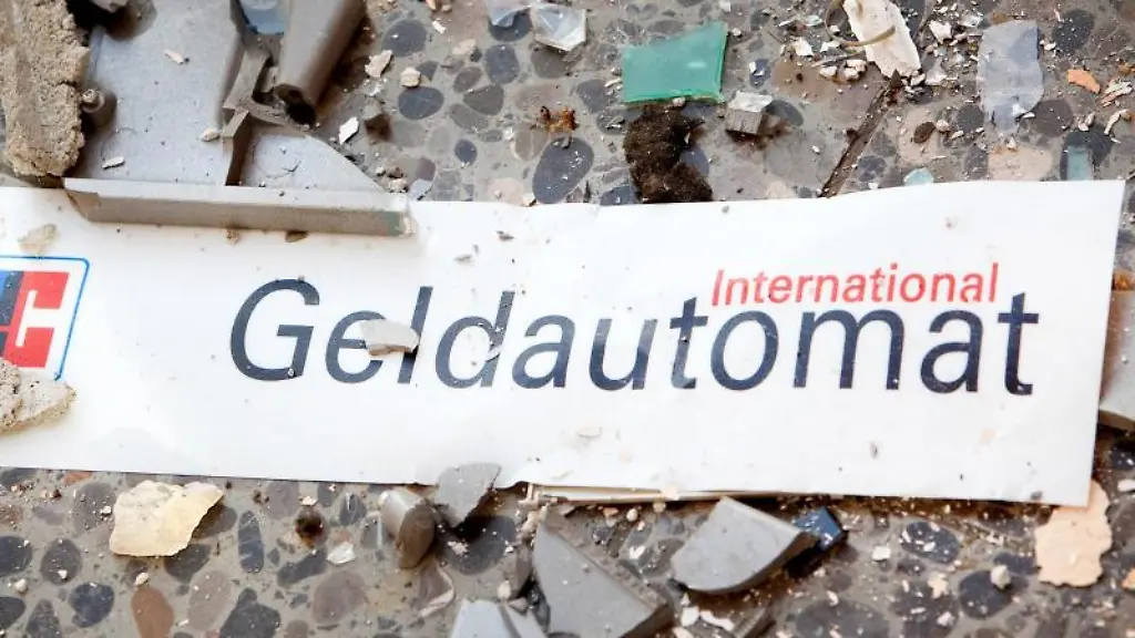 Splitter-und-ein-Schild-mit-der-Aufschrift-Geldautomat-liegen-auf-dem-Boden-vor-einem-gesprengten-Geldautomaten