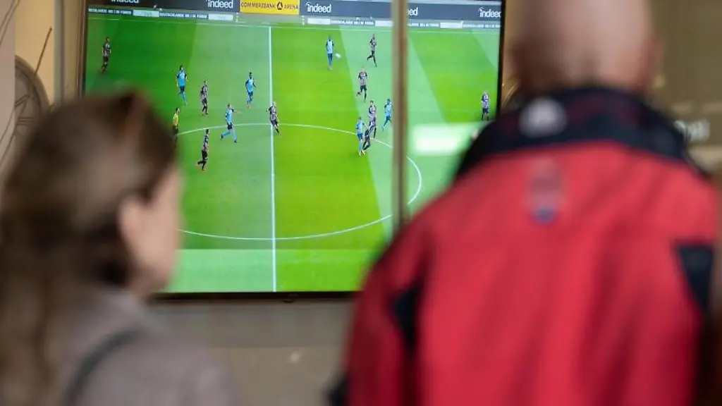 Zwei-Menschen-verfolgen-ausserhalb-einer-Bar-ein-Fussballspiel