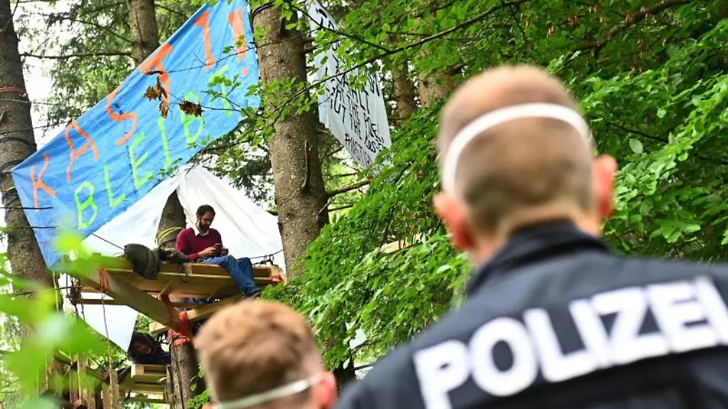 Polizisten-stehen-am-Rande-des-Protestcamps-im-Forst-Kasten-nahe-Muenchen