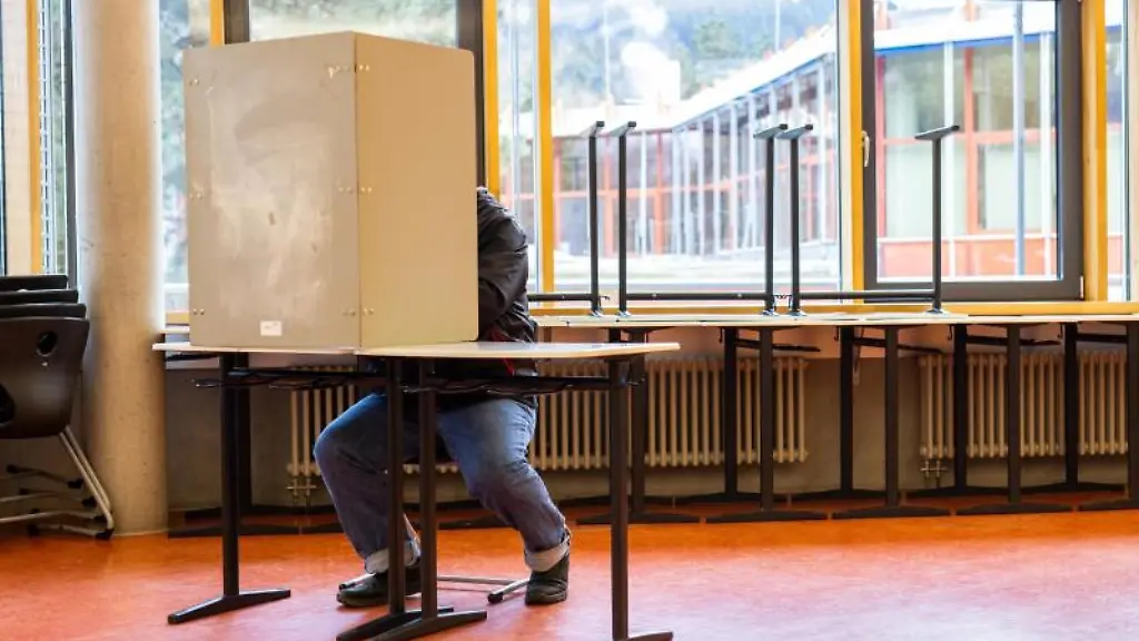 Ein-Waehler-sitzt-in-einem-Wahllokal