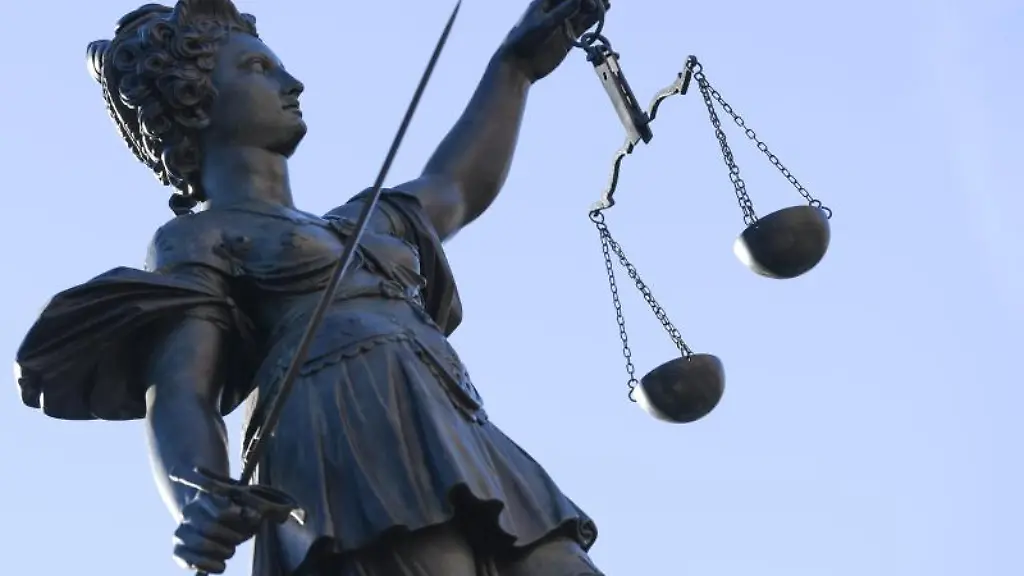 Eine-Statue-der-Justitia-steht-unter-freiem-Himmel