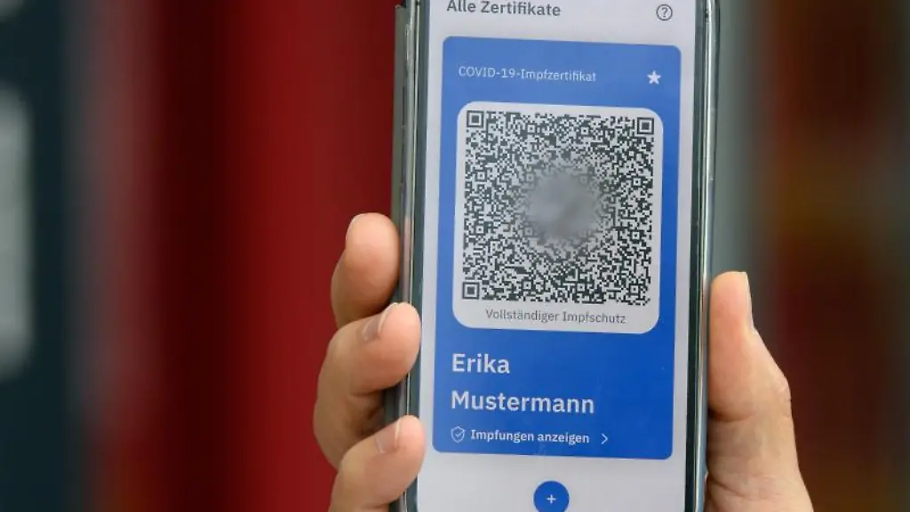 Der-digitale-Impfpass-wird-in-die-Kamera-gehalten