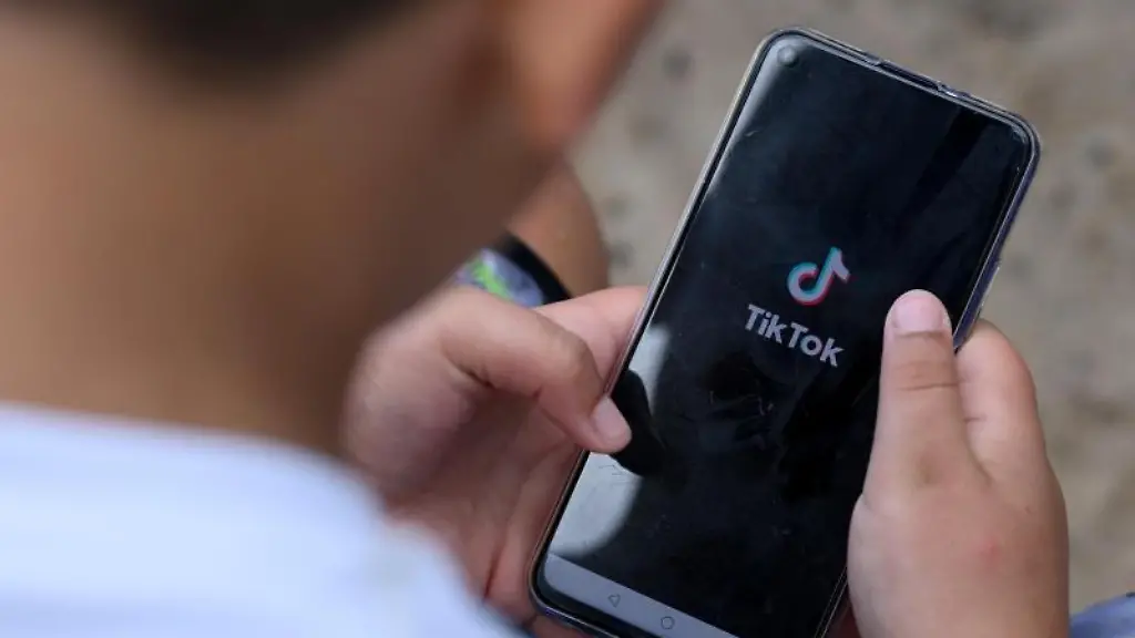 Ein-Junge-haelt-ein-Smartphone-in-den-Haenden-auf-dem-das-Logo-der-Kurzvideo-App-TikTok-zu-sehen-ist