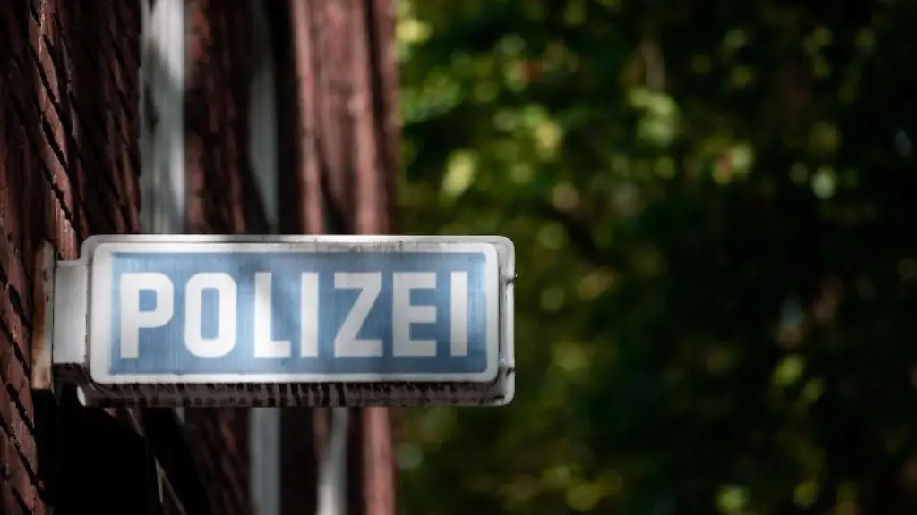 Ein-Schild-auf-dem-Polizei-steht-haengt-an-einer-Wache