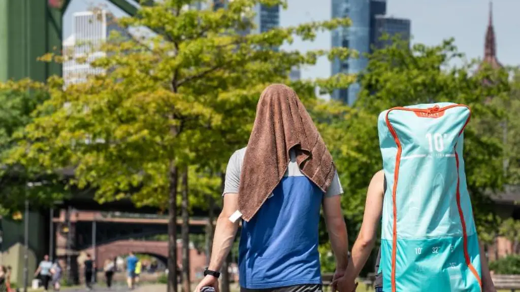 Ein-Mann-laeuft-mit-einer-Frau-durch-einen-Park