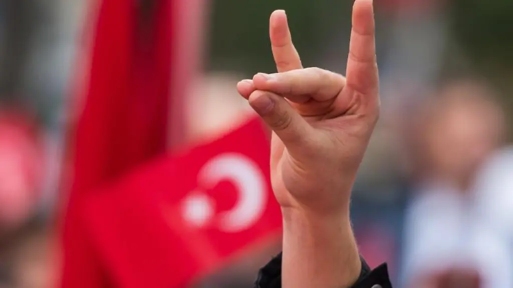 Eine-Hand-zeigt-den-Wolfsgruss-der-Grauen-Woelfe