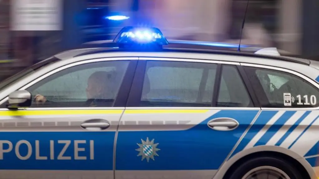 Ein-Polizeiwagen-faehrt-mit-Blaulicht-durch-die-Innenstadt