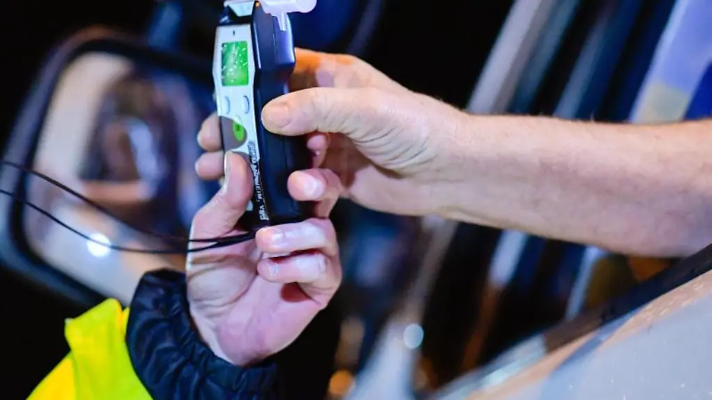 Polizisten-reichen-ein-Alkoholmessgeraet-in-eine-Fahrerkabine