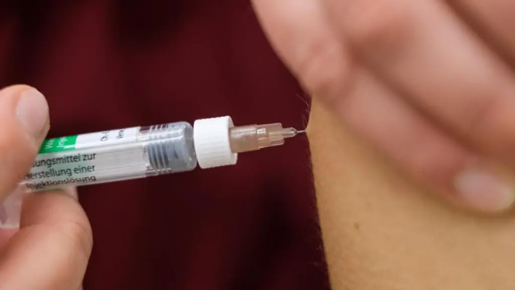 Eine-Arzthelferin-impft-eine-Patentin-mit-einer-Spritze