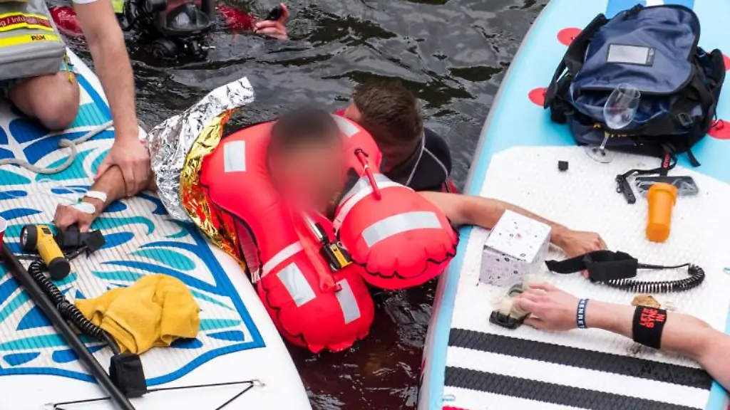 Ein-Mann-M-der-mit-seinem-Fuss-unter-Wasser-in-einem-Siel-festhaengt-wird-von-der-Feuerwehr-befreit