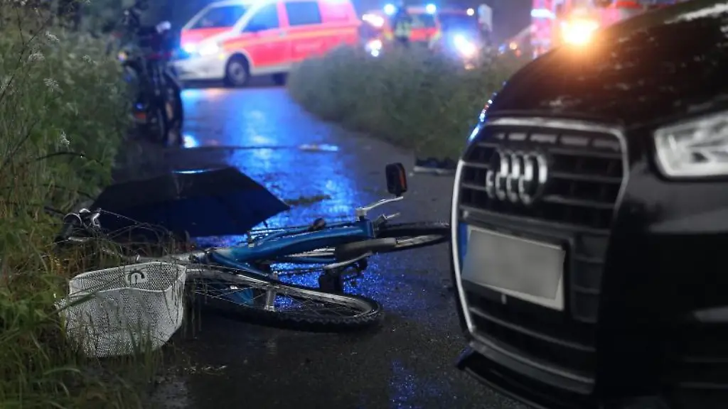 Ein-beschaedigtes-Fahrrad-liegt-neben-einem-Auto-auf-dem-Boden