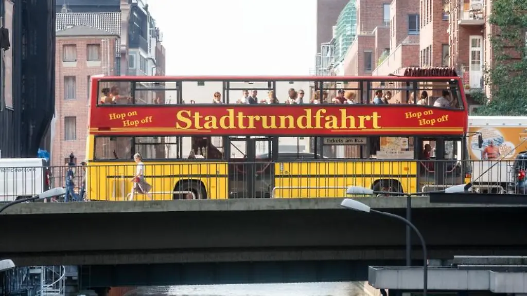Ein-Stadtrundfahrt-Bus-faehrt-auf-einer-Bruecke-ueber-den-Bleichenfleet