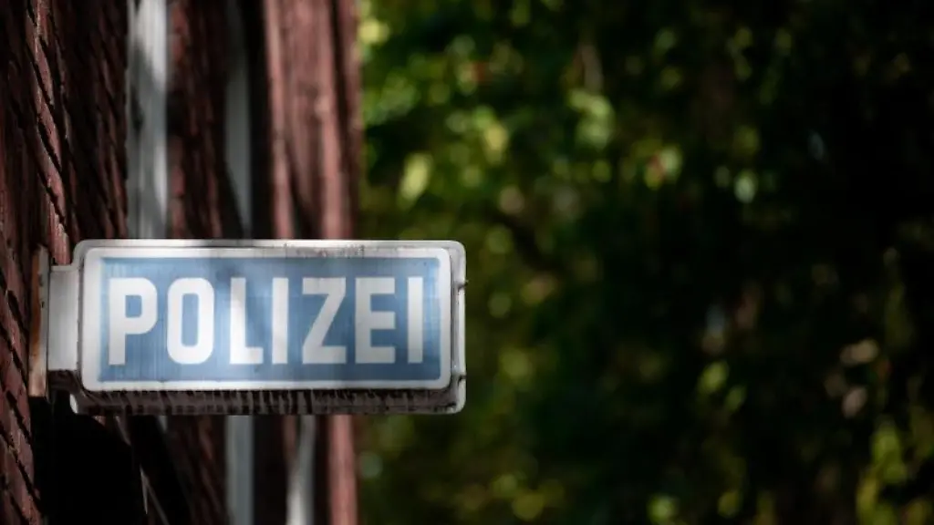 Ein-Schild-auf-dem-Polizei-steht-haengt-an-einer-Wache