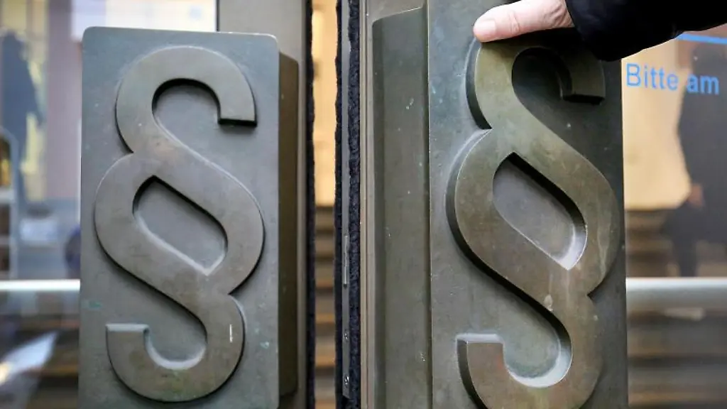 Paragrafen-Symbole-sind-an-Tuergriffen-am-Eingang-zu-einem-Landgericht-angebracht