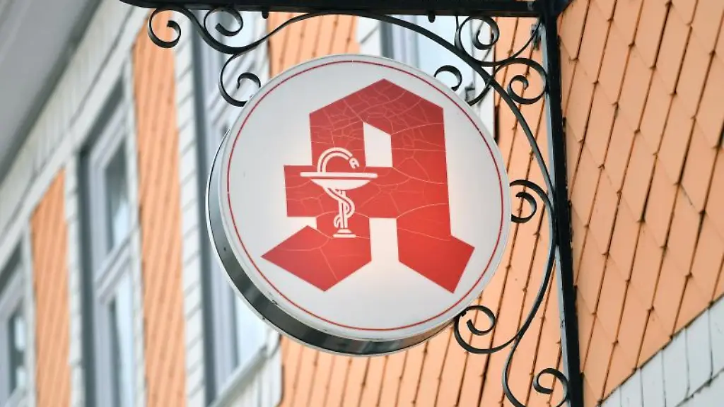 Das-Apothekenzeichen-haengt-an-der-Hausfassade-ueber-dem-Eingang-zu-einer-Apotheke