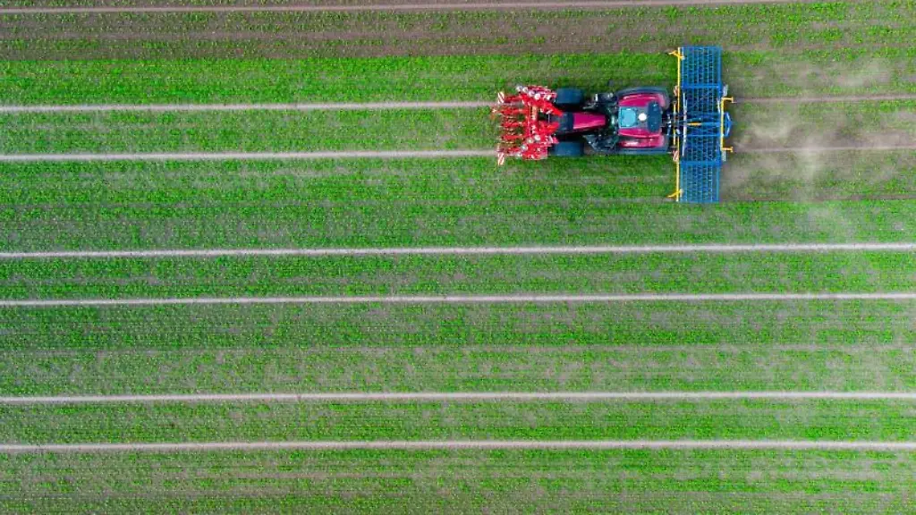 Ein-Landwirt-faehrt-mit-seinem-Trecker-ueber-ein-Feld